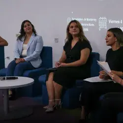 5 mujeres sentadas en sillones azules platicando