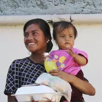 una señora y su pequeña hija después de recibir la ayuda