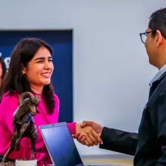Candidata a graduar saludando a un reclutador