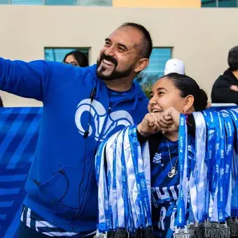 Colaboradores tomándose una foto sosteniendo las medallas