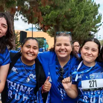 Colaboradores y estudiantes sonriendo en la meta 