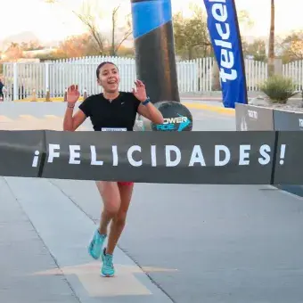 Chica cruzando la meta de una carrera